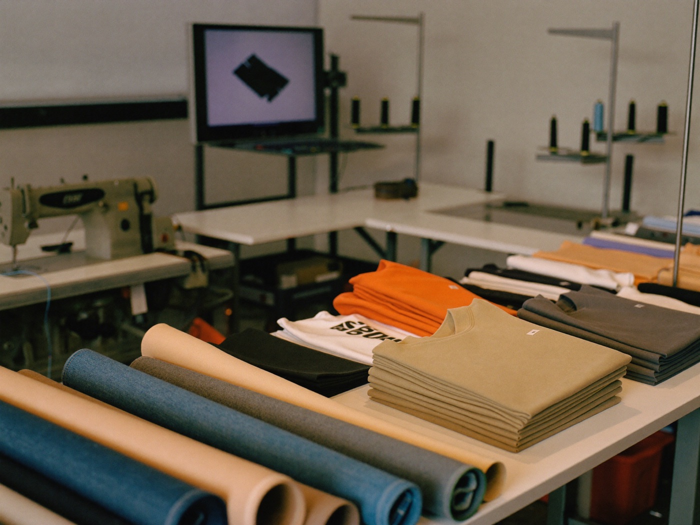 Taller textil con telas y máquinas de coser